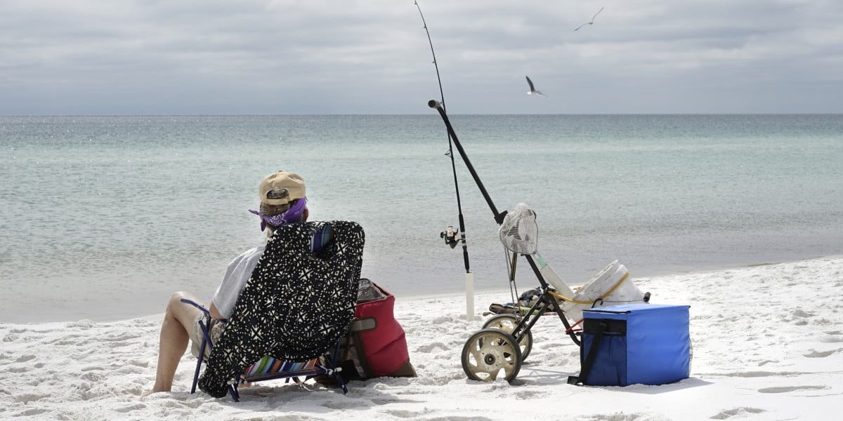 Relaxed mature woman fishing in the Gulf of Mexico, looking out to sea.
