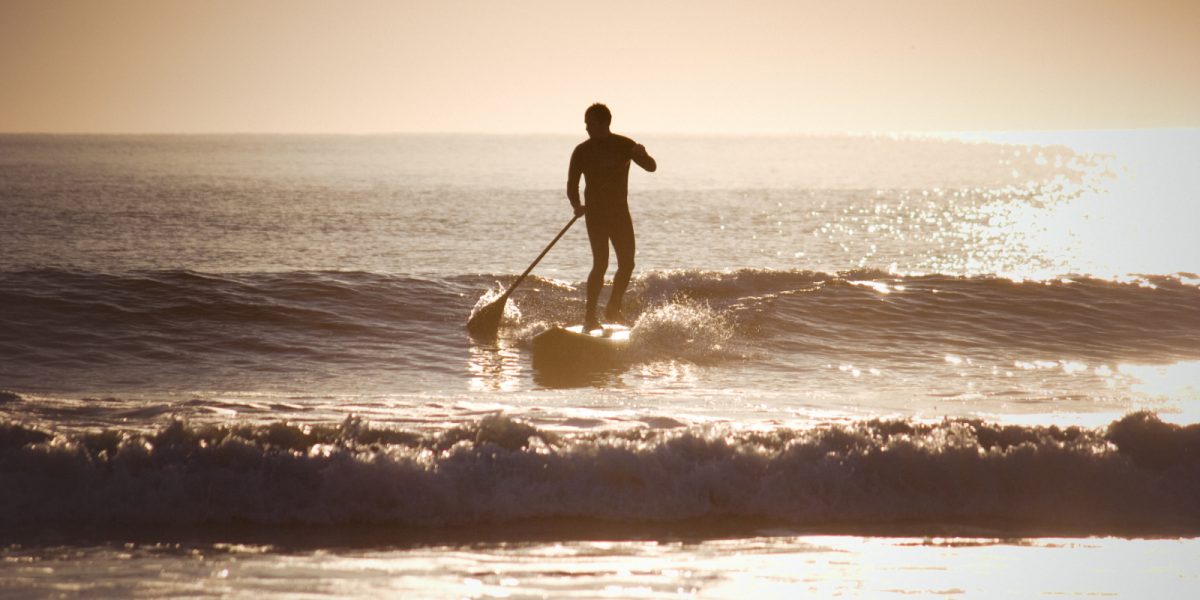 Silhouette of a man paddle boarding